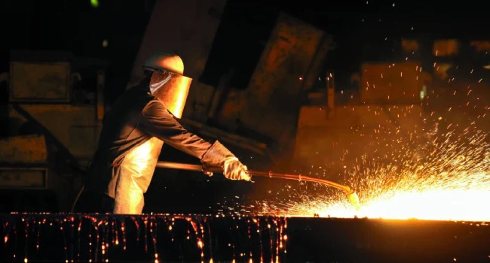 A steelworker guiding molten steel on an MMD casting floor